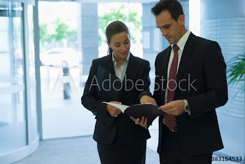 Corporate business people looking at schedule in lobby