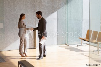 Corporate business people shaking hands in sunny modern office