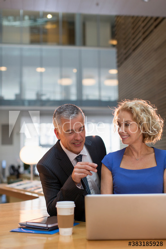 Corporate business people using laptop in office atrium