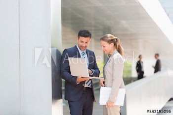 Corporate business people using laptop outdoors