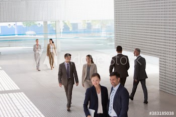Corporate business people walking in modern lobby