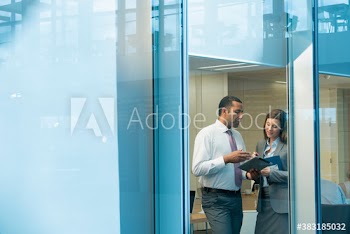 Corporate business people with digital tablet in office window