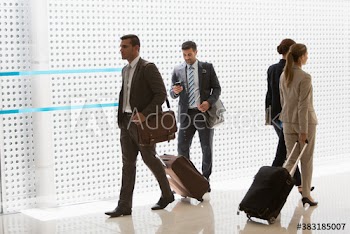 Corporate business people with suitcases in airport corridor