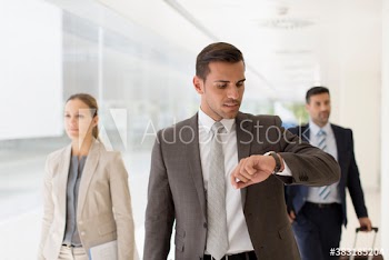 Corporate businessman checking time on wristwatch