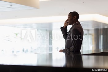 Corporate businessman talking on smart phone in office