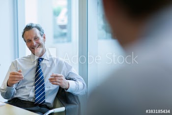 Corporate businessman talking with colleague in meeting