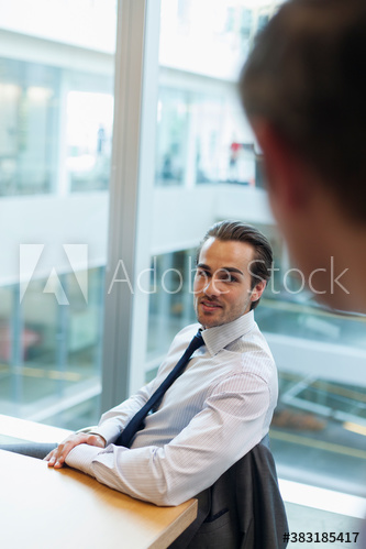 Corporate businessman talking with colleague in office