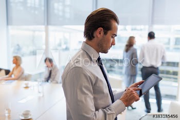 Corporate businessman using digital tablet in conference room