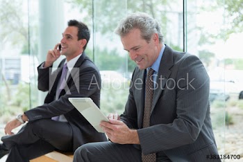 Corporate businessman using digital tablet in lobby