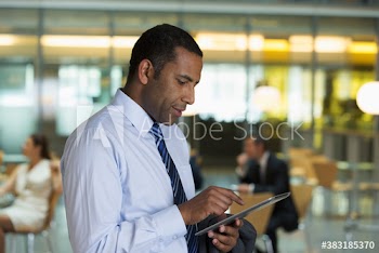 Corporate businessman using digital tablet in office