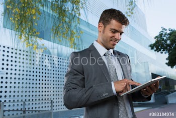 Corporate businessman using digital tablet outside modern building