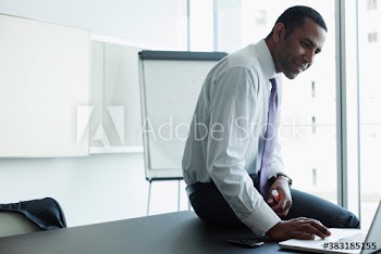 Corporate businessman using laptop in conference room