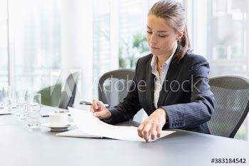 Corporate businesswoman reviewing paperwork in conference room