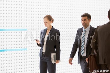 Corporate businesswoman using smart phone in corridor
