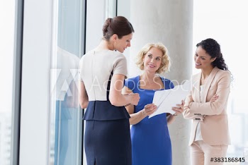 Corporate businesswomen discussing paperwork in window