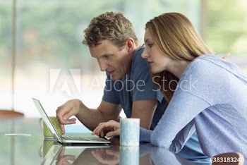 Couple drinking tea and using laptop