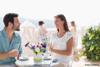 Couple enjoying coffee on sunny balcony