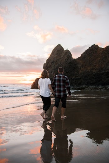 Couple Holding Each Others Hand While Walking on Shore