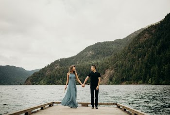 couple holding hands near body of water