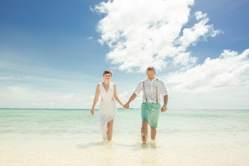 Couple Holding Hands While Walking on Beach