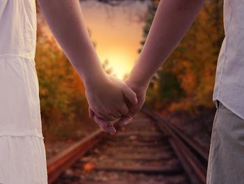Couple Holding in Train Rails during Golden Hour