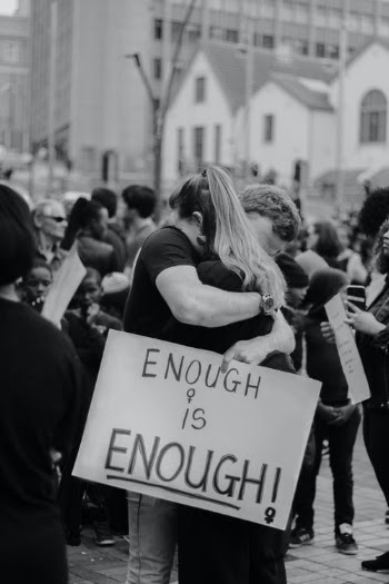 Couple hugging and holding sing with ENOUGH IS ENOUGH inscription · Free Stock Photo