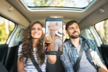 Couple in car showing smartphone mockup Free Psd