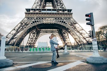 couple kissing in front of Eiffel tower during daytime
