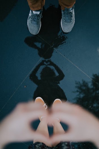 Couple reflecting in puddle on street · Free Stock Photo