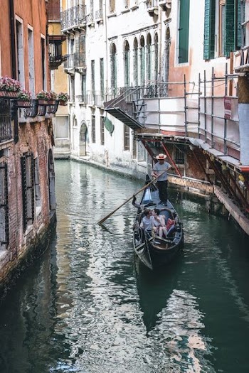 couple riding boat in Venice Canal at daytime