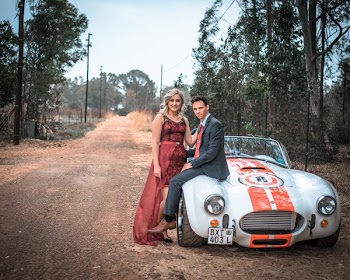 Couple Sitting on Silver Vehicle on Dirt Road