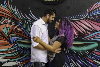 Couple Smiling Near Wall Art Work