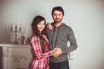 Couple Standing Near Fireplace Mantel