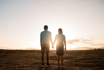 Couple Standing on Field During Golden Hour
