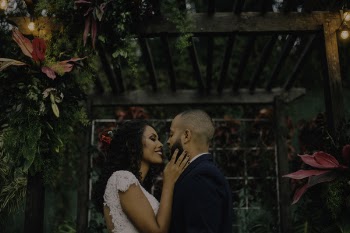 Couple Under Garden Arch Surrounded With Flowers