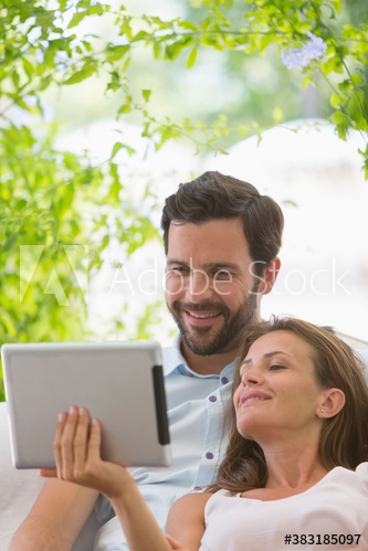 Couple using digital tablet on patio
