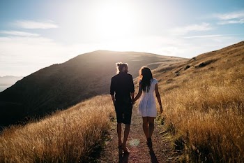 couple walking near mountain range