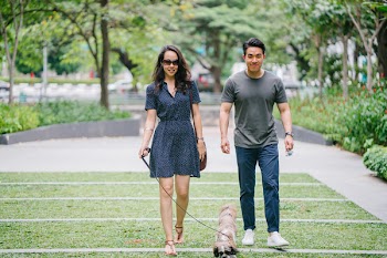 Couple Walking With Dog on Green Grass