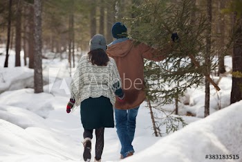 Couple with Christmas tree in snowy woods
