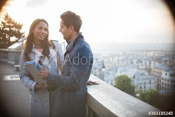 Couple with digital tablet on balcony overlooking Paris, France