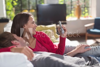Couple with remote control on sofa