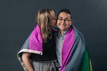 Couple Wrapped In Pride Flag Kiss