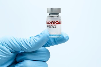 COVID-19 vaccine bottle in scientist's hand