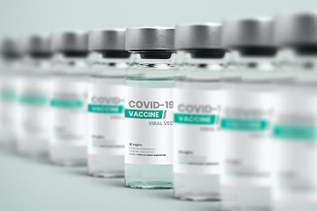 COVID-19 vaccine injection glass bottles in a row