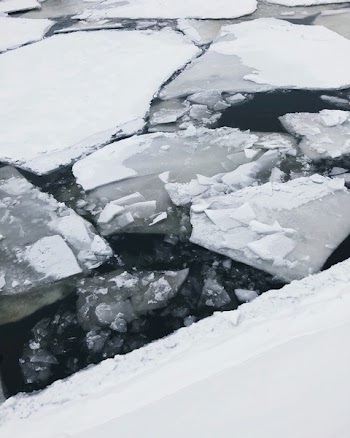 Cracked Ice Floating on Body of Water