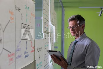 Creative businessman with digital tablet brainstorming in office