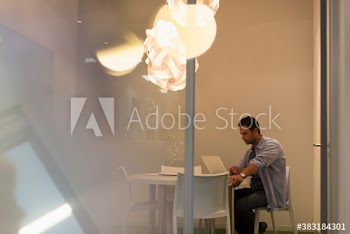 Creative businessman working at laptop in modern conference room
