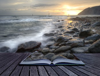 Creative concept image of seascape landscape coming out of pages in magical book