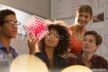 Creative young business people examining prototype in meeting