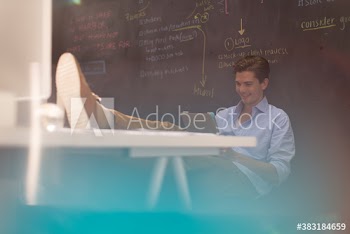 Creative young businessman using digital tablet at desk